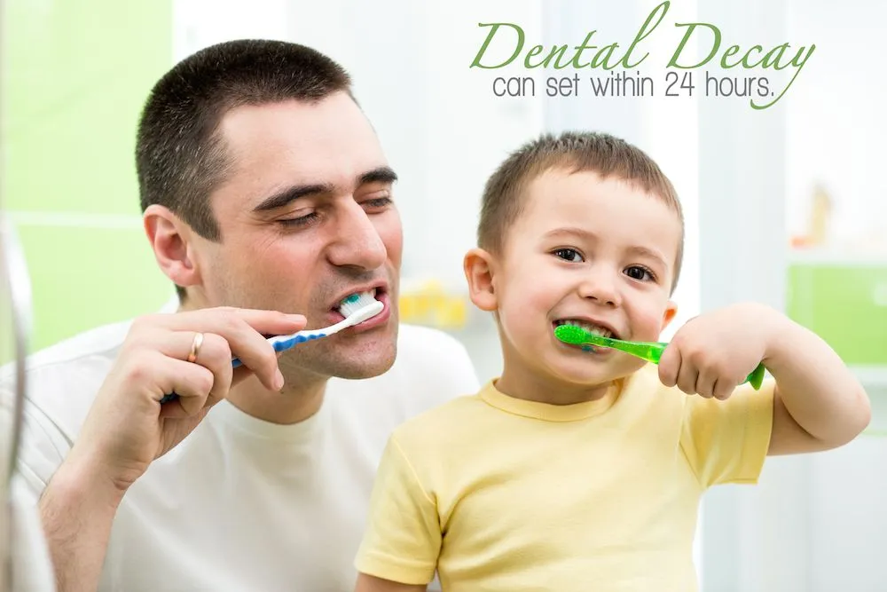 Parent and child brushing teeth together