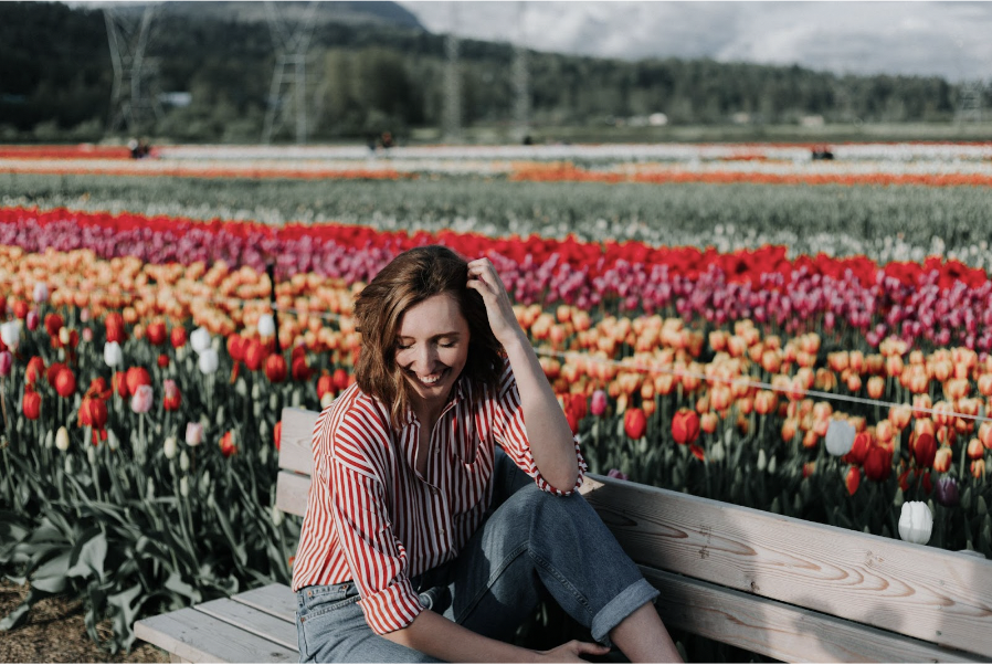 Woman sitting in a colorful flower field
