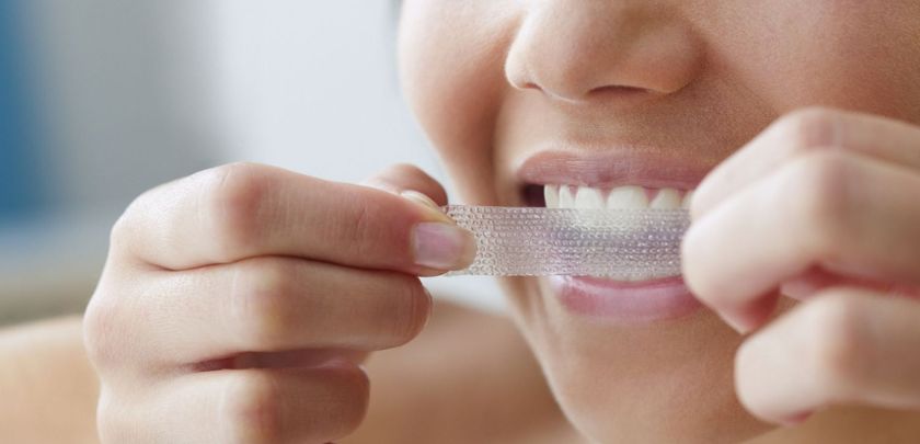 Patient using white strips on teeth