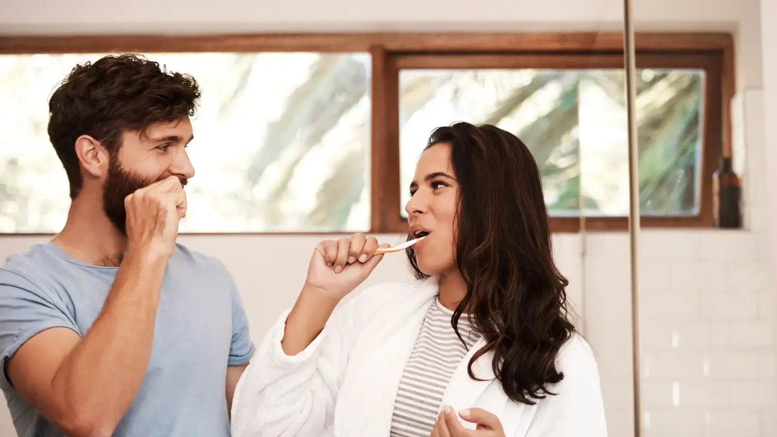 A couple brushing their teeth together