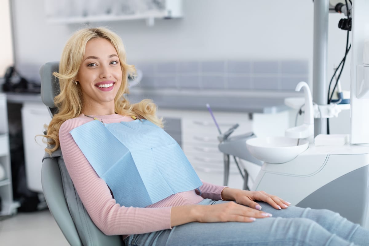 Patient smiling while sitting in a dental chair